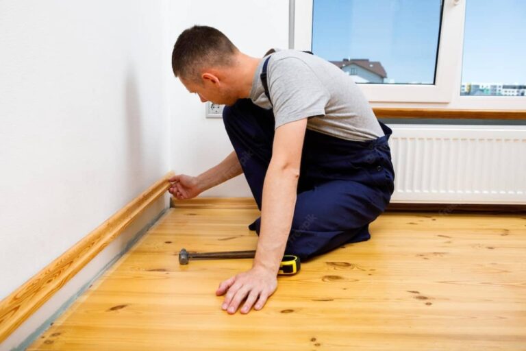 Technician Installing Skirting Boards in Home