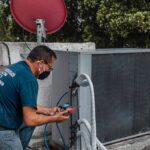 Technician servicing an HVAC system for improved energy efficiency and indoor comfort.