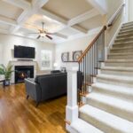Ceiling fan running in a bright living room with air conditioner unit, improving air circulation and cooling efficiency.