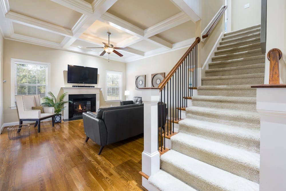 Ceiling fan running in a bright living room with air conditioner unit, improving air circulation and cooling efficiency.